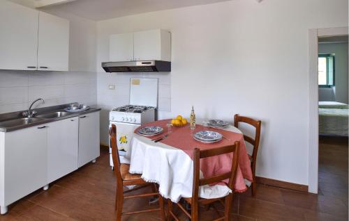 a kitchen with a table and a sink and a stove at 1 Bedroom Cozy Apartment In Longobardi in Longobardi