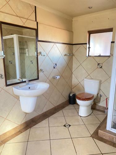 a bathroom with a toilet and a sink at The Red room Serengeti sands in Phalaborwa