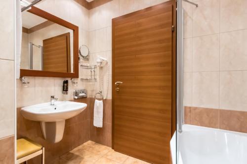 a bathroom with a sink and a toilet and a shower at Hotel Corvinus Vienna in Vienna