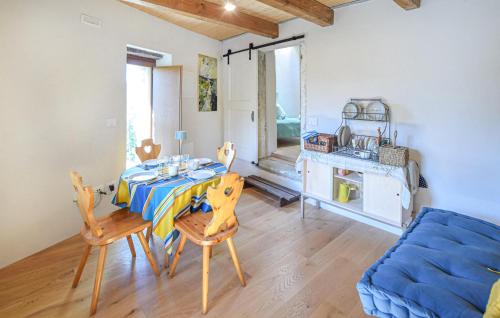 a dining room with a table and a blue couch at Lovely Home In San Pietro A Dame in Poggioni