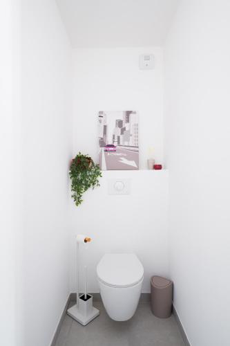 une salle de bain avec une baignoire blanche dans un mur blanc dans l'établissement Appartement neuf cosy en ville 4 pers, à Annecy