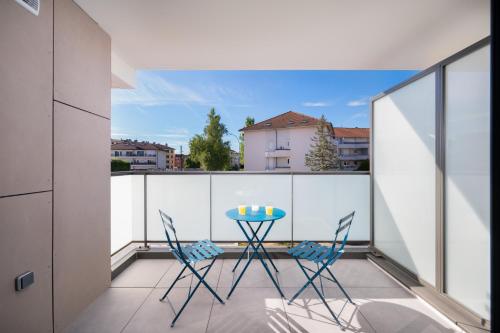 un patio avec une table et des chaises sur un balcon dans l'établissement Appartement neuf cosy en ville 4 pers, à Annecy
