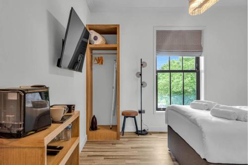 a bedroom with a bed and a tv on the wall at Pass the Keys Larkey View a Tranquil Space for Two in Chartham