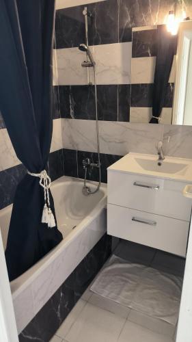 une salle de bain avec un lavabo et une baignoire et un lavabo dans l'établissement Pierre et Vacances Palm d'Azur 459, à Cannes
