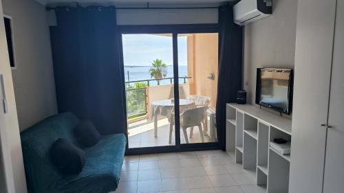 Cette chambre dispose d'une porte coulissante en verre offrant une vue sur l'océan. dans l'établissement Pierre et Vacances Palm d'Azur 459, à Cannes