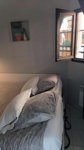 une chambre avec un lit avec des oreillers et une fenêtre dans l'établissement Pierre et Vacances Palm d'Azur 459, à Cannes