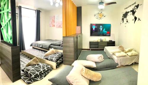 a room with two beds and a flat screen tv at Luxurious Deluxe Apartment - EhubStay Mactan Cebu - Saekyung Condo Looc in Lo-oc