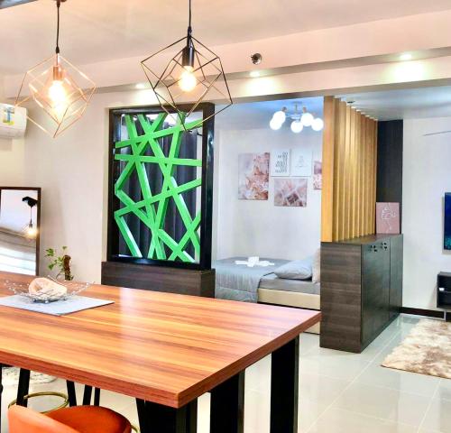 a dining room with a table and a bedroom at Luxurious Deluxe Apartment - EhubStay Mactan Cebu - Saekyung Condo Looc in Lo-oc