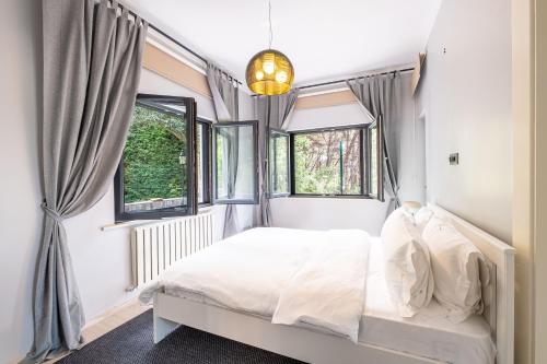 a bedroom with a bed and two windows at Villa 23 in Adalar