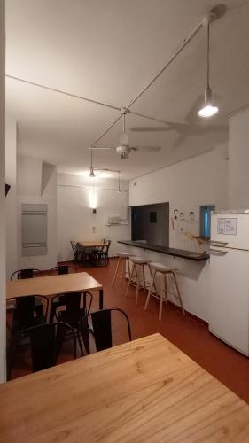 ブエノスアイレスにあるRío Plateado Hostelのテーブルと椅子が備わる空き部屋、キッチンが備わる客室です。