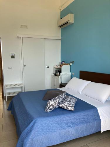 a bedroom with a bed with two pillows on it at Jonio B&B in Acireale