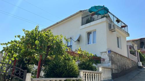 a white house with a balcony on top of it at Cosy Apartment Sea View in Kumbor in Kumbor