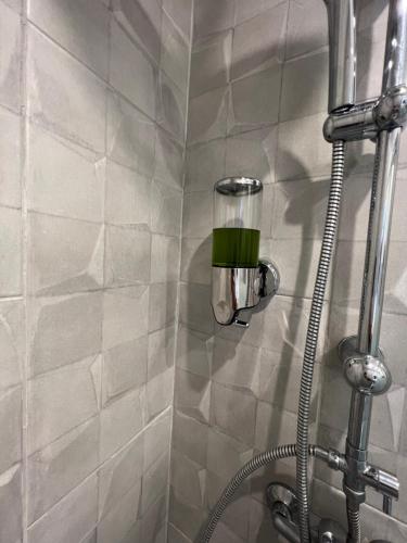 une douche avec un tuyau et un pommeau de douche dans l'établissement Suite vue Montmartre & balcon, à Paris