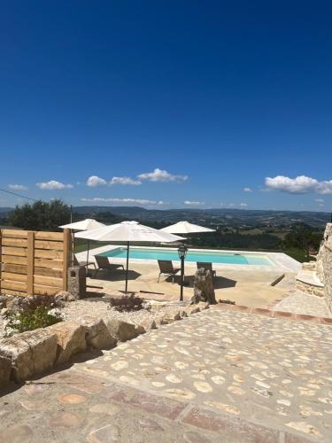a swimming pool with umbrellas and a swimming pool at Agriturismo La Quercia Bella in Frontignano