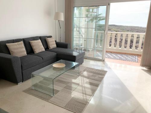 a living room with a couch and a glass coffee table at Paraiso Ocean Panorama in Palm-Mar