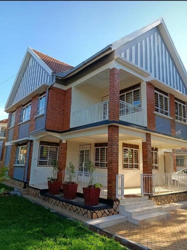 a large brick house with potted plants in front of it at Shiloh homes and travel agency in Kampala