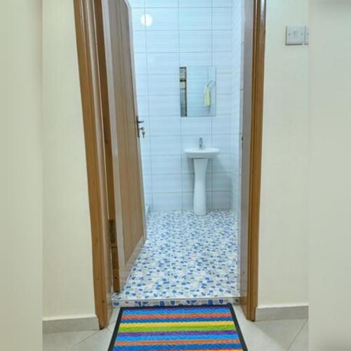 a bathroom with a shower with a sink and a toilet at Shiloh homes and travel agency in Kampala