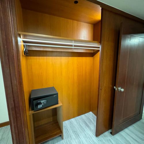 a room with a closet with a tv and a door at XinsheHotel - Chungli in Zhongli