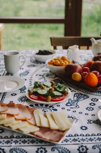 a table topped with plates of cheese and fruit at Arte in Kazbegi in Stepantsminda
