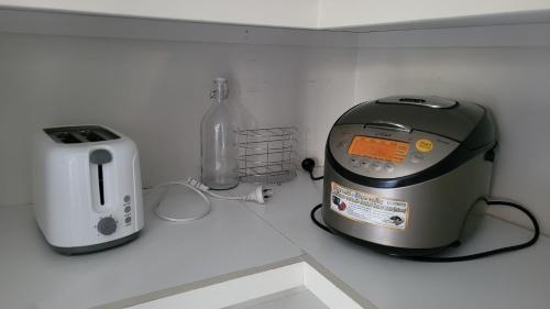 a toaster and a toaster sitting on a counter at Bliss Stay Cosy Home 3Bedroom 2Bath in Croydon