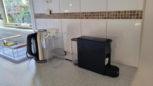 a kitchen counter with a coffee maker and a blender at Bliss Stay Cosy Home 3Bedroom 2Bath in Croydon