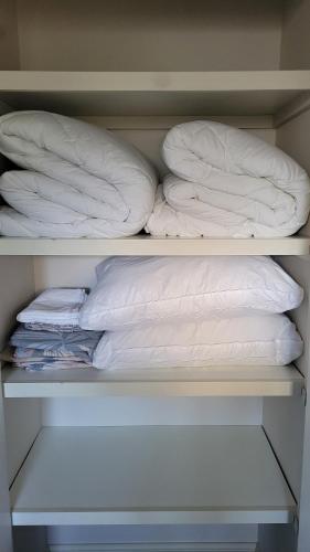 two stacks of pillows on a shelf in a closet at Bliss Stay Cosy Home 3Bedroom 2Bath in Croydon