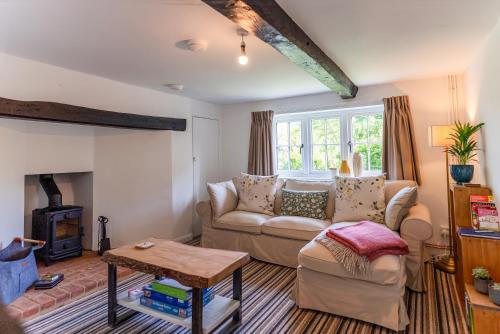 a living room with a couch and a fireplace at Redshank Cottage in West Dean