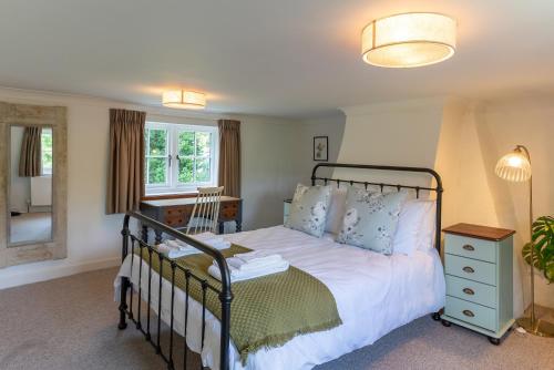 a bedroom with a bed and a mirror at Redshank Cottage in West Dean