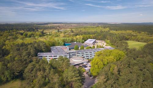 an aerial view of a building in the middle of a forest at WestCord ApartHotel Boschrijck in West-Terschelling
