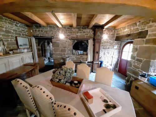 un salon avec une table et un mur en pierre dans l'établissement Manoir de Kergoat Vras, à Plounérin