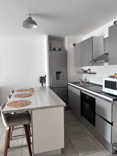 une cuisine avec des armoires blanches et un comptoir dans l'établissement Appartement au centre de Villeurbanne, à Villeurbanne