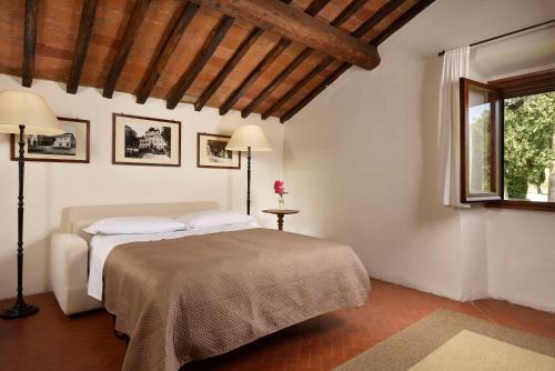 a bedroom with a bed and two lamps and a window at Villa Ortaglia Estate in Vaglia