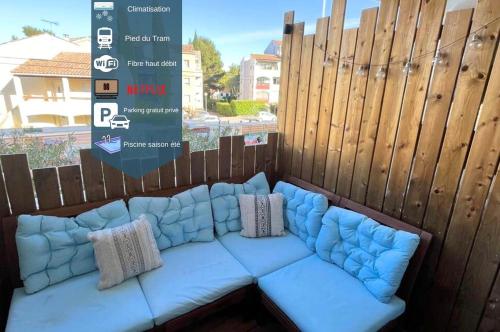 a blue couch in front of a wooden fence at Joli T2/ Tram/ Clim/ Parking/ Wifi/ Piscine in Montpellier