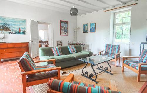 un salon avec un canapé vert et des chaises dans l'établissement Nice Home In La Boissière Des Lande, à La Boissière-des-Landes