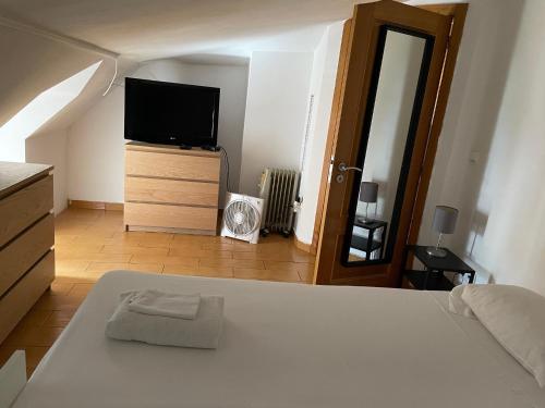 a bedroom with a bed and a flat screen tv at Vissaium Rooms- checkin até as 20h in Viseu