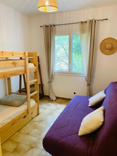 une chambre avec un lit superposé et une fenêtre dans l'établissement Magnifique Villa typique du Sud avec Piscine privée et jardin méditerranéen, à Saint-Vincent-de-Barbeyrargues
