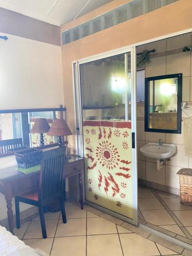 a bathroom with a shower with a sink and a table at Texas lodge in Phalaborwa
