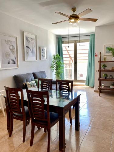 a dining room with a table and chairs and a couch at Casa Bubal by Best Holidays Fuerteventura in Corralejo