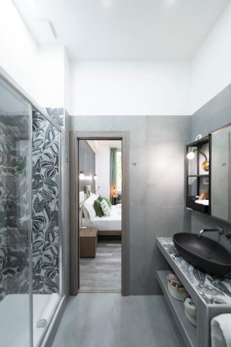 a bathroom with a sink and a shower and a bedroom at Trastevere Luxury Rooms in Rome