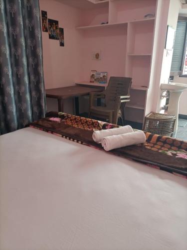 a room with a bed with a table and a tableasteryasteryasteryasteryastery at VIDYA Homestay in Hampi