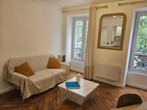 un salon avec un canapé et une table dans l'établissement Highstay Champs Elysées ARC de triomphe, à Paris