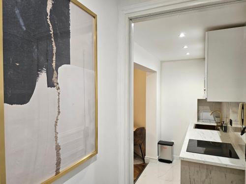 une cuisine avec un grand tableau mural dans l'établissement Highstay Champs Elysées ARC de triomphe, à Paris