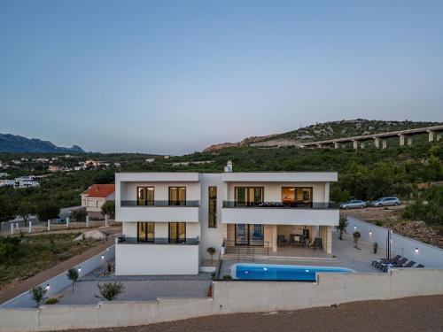 a large white house with a swimming pool at Villa Malusy ZadarVillas in Rovanjska