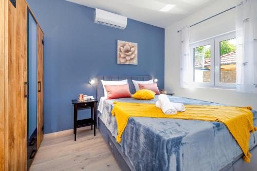una camera blu con un letto con una coperta gialla di Holiday Villa Effort in Skradin - Šibenik a Vačani