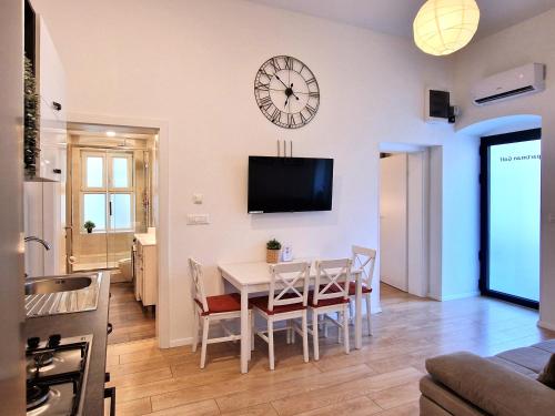 comedor con mesa y reloj en la pared en Apartman Golf, en Zagreb