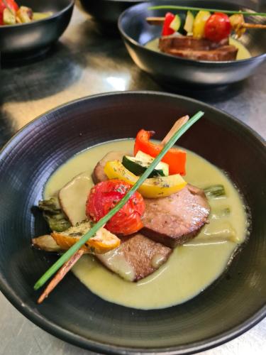 a plate of food with meat and vegetables with chopsticks at Logis Hotel Eden Lac in Savines