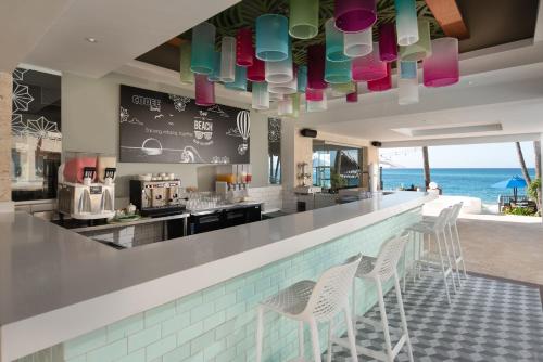 a bar with chairs and a view of the ocean at Select at Casa Marina Adults Only All Inclusive in Sosúa