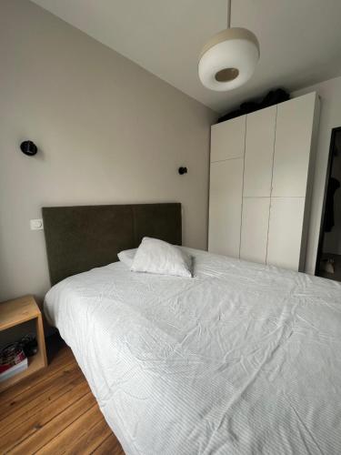 - une chambre avec un grand lit et un couvre-lit blanc dans l'établissement Cosy Canal St Martin Apartment, à Paris