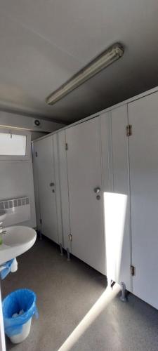 a room with white lockers and a blue bucket at Wioska na Klifie - Helska 11 in Hel