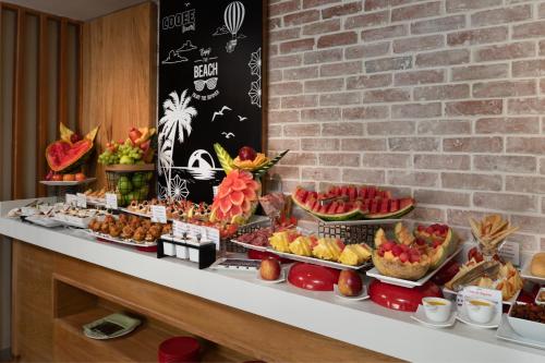 a buffet with fruits and pastries on a table at Select at Casa Marina Adults Only All Inclusive in Sosúa